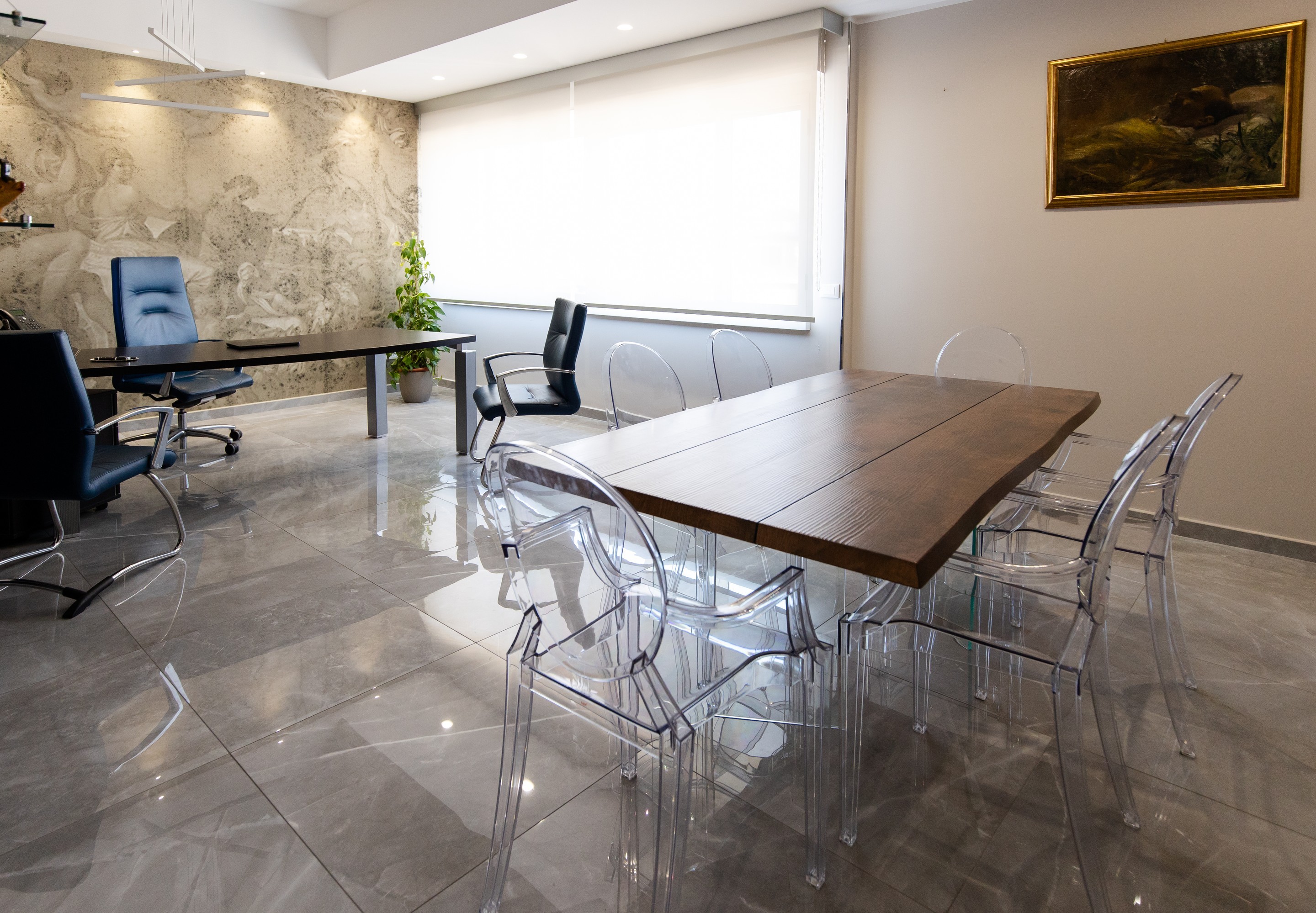 La sala riunioni dello Studio, con il tavolo in legno e le postazioni di lavoro.